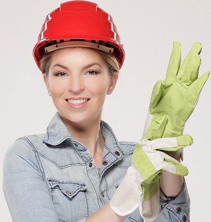 Handwerkerin mit Sicherheitshelm und Handschühen